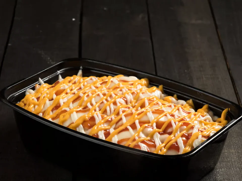 Yaroa Maduro y Pollo - A beloved Dominican yaroa featuring sweet plantains and seasoned chicken, topped with melted cheese and our special sauces.